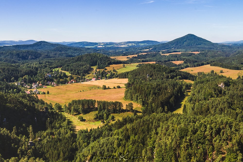 The 35 mm for a second time. This one emphasizes the meadow, the houses, and the distant hilltop.