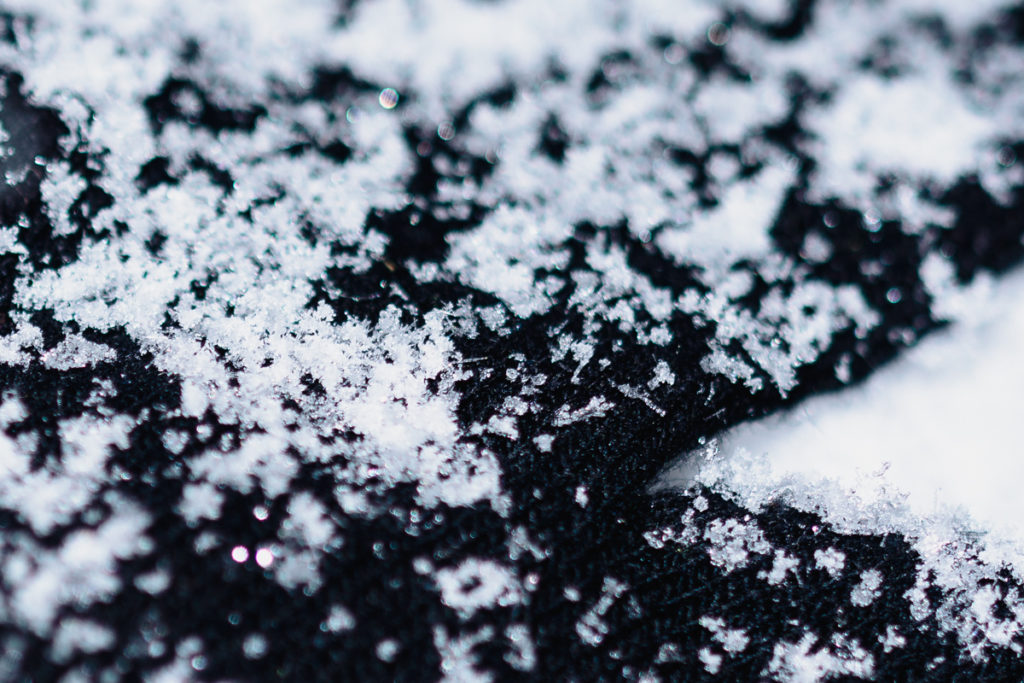 This picture shows flakes that stuck on a black glove. It serves as a background and a snowflake “catcher.” You can also see that these flakes were not ideal subjects—they landed a bit melted.