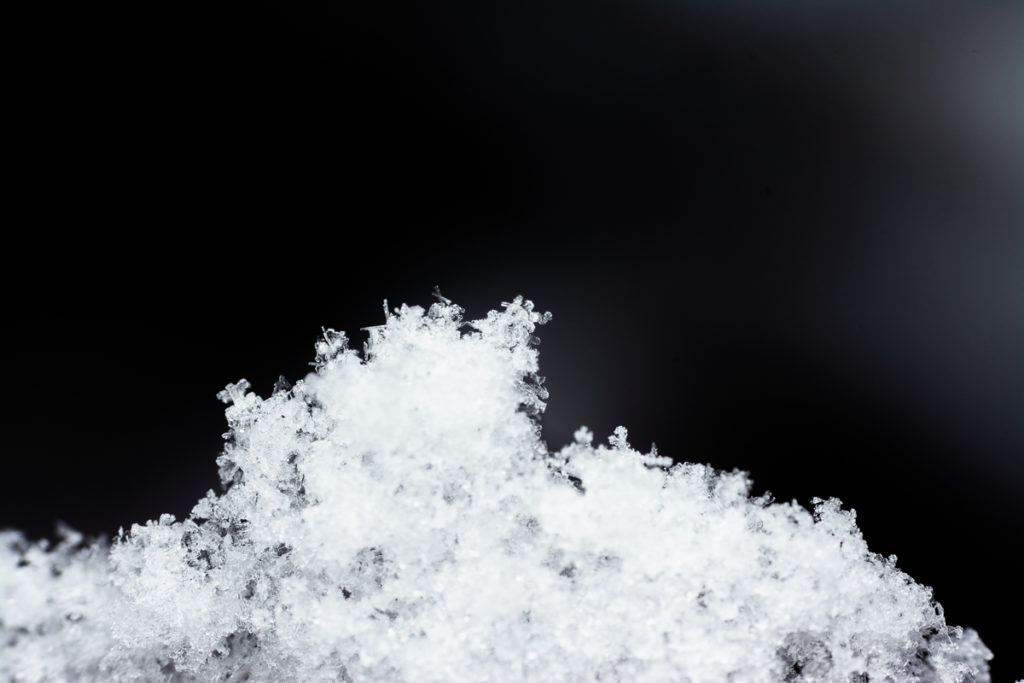 This picture shows a clump of snowflakes. You can see some pretty shapes around its edges.