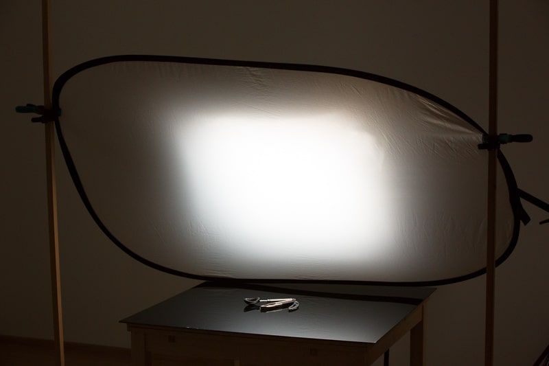 The diffusion-box light from the rear is further diffused by the board, which is translucent here (though it is normally reflective). For illustration purposes the surroundings are strongly lighted here compared how they’d be lighted in a real shoot.
