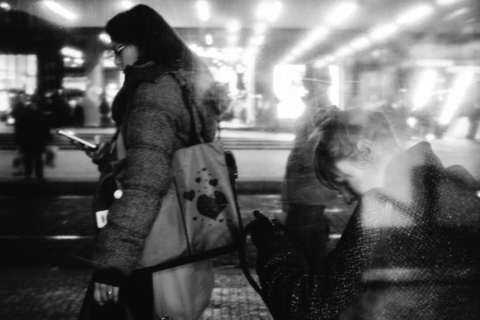 A black and white preview suppresses all the distracting swaths of color. That lets other things shine through: the line of lights from the shopping center, opposite to the line formed by the tilts of both women’s heads. This composition guides the viewer’s eyes from one woman to the other and doesn’t force them to wonder if the woman on the right is also searching for her phone like the one on the left.