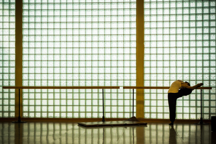 The dividing columns of the glass-block wall are an important element in the photo, and they throw shadows on both the dancer and the pattern created by the glass blocks themselves. 