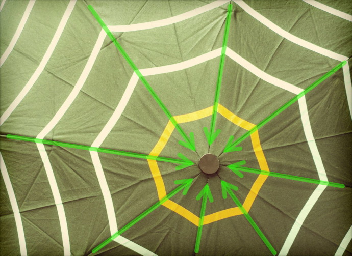 The seams (emphasized here with arrows), the wrinkles, and the pattern all lead the viewer’s eyes towards the center of the umbrella, which is located on a golden-crop point. In this case, the whole umbrella is the subject. Panasonic Lumix DMC-LX 3, 1/13 s, f/3.2, ISO 200, focus 6.8 mm (32 mm equiv.)