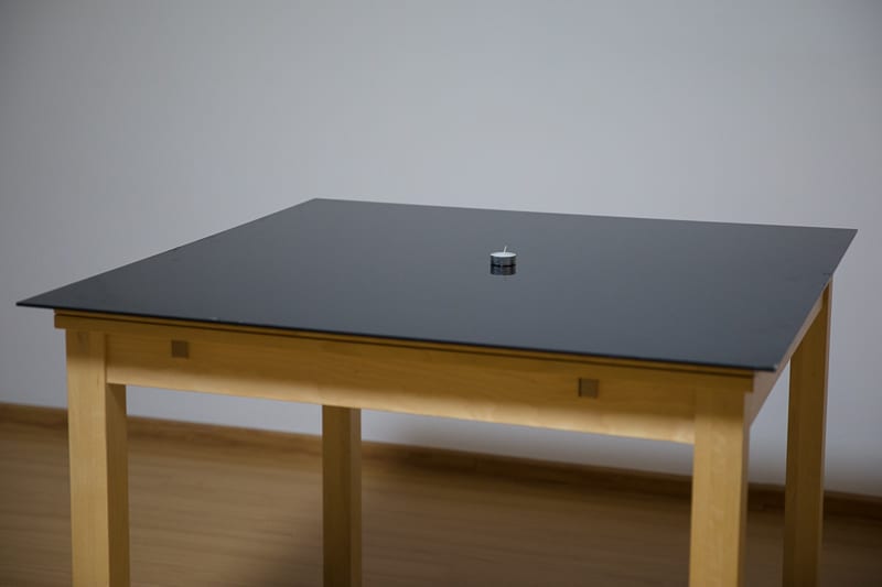 A table for experiments. A black-glass tabletop creates a slightly mirrored image.