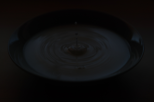 Illustration photo of a drop falling on a water surface. The goal was to freeze the drop’s motion using a short exposure time. Even though a minimal f-stop was used, the photo is still underexposed due to a lack of light.