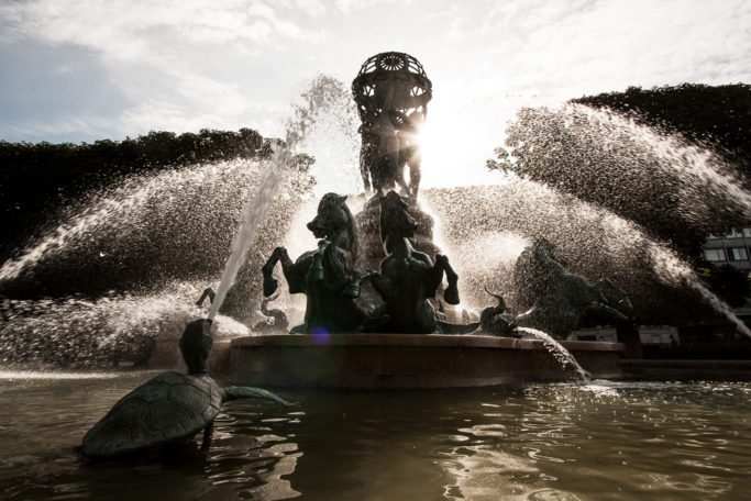 A fountain photographed facing towards the sun.