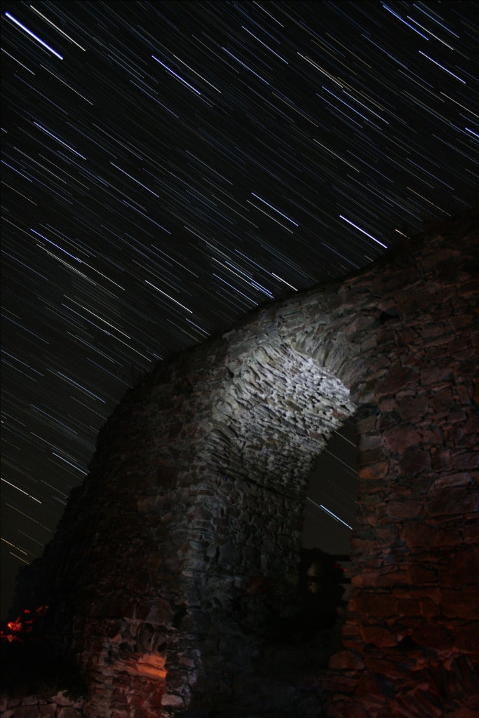How to photograph star trails: starry sky over a gate.