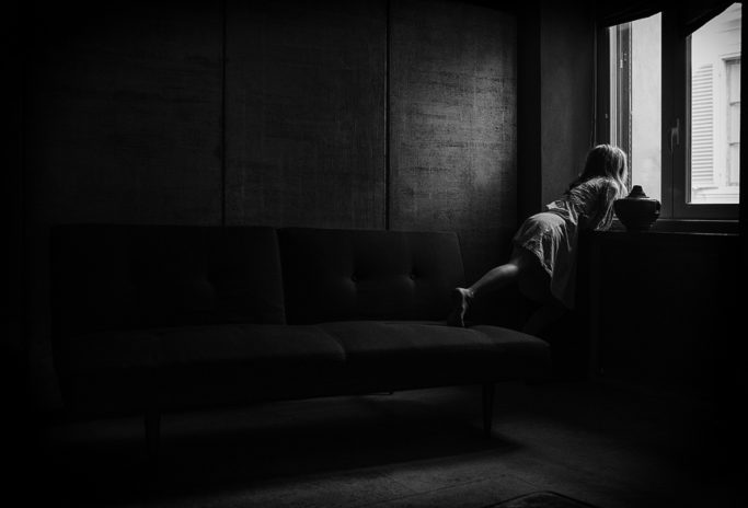 Photographing Kids in Colors and Black and White: child looking out of the window.