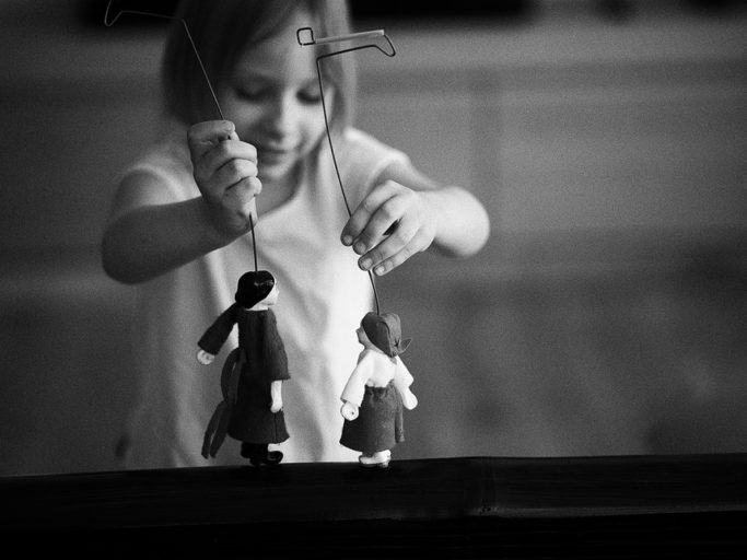 Photographing Kids in Colors and Black and White: child playing with puppets.