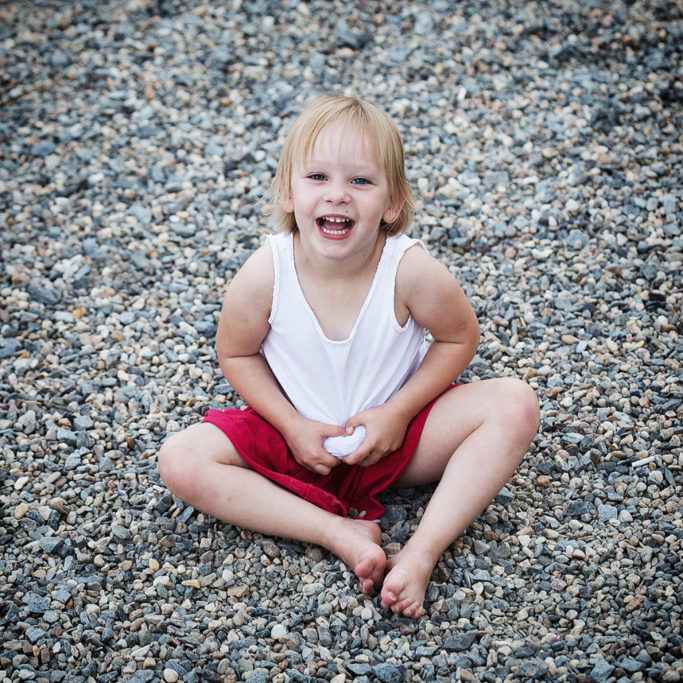 Photographing Kids in Color and Black and White: Neutral colors of stones in combination with red.