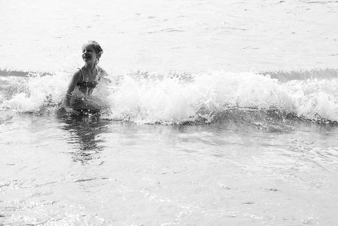 Photographing kids against the light: child enjoying the sea.