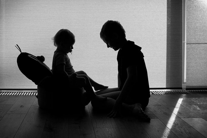 Photographing kids against the light: the partial silhouette of siblings.